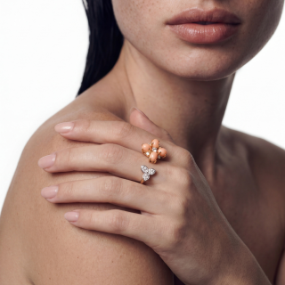 gold ring featuring coral and brilliant cut diamonds worn