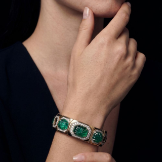 Gold bracelet with engraved Zambian emeralds and diamonds worn