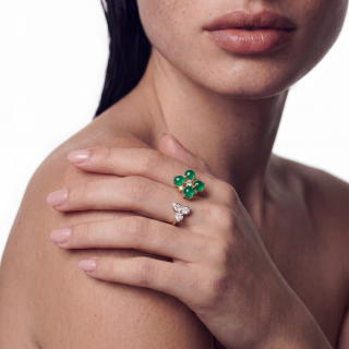 gold ring featuring coral and brilliant cut diamonds worn